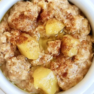 Bowl of warm Apple Cinnamon Oatmeal topped with apple slices and cinnamon.