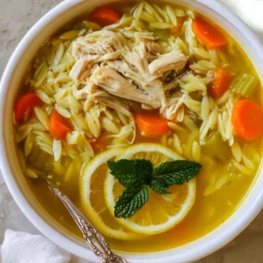 Bowl of Chicken Lemon Orzo Soup with fresh lemon and herbs