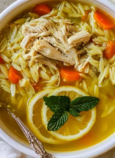 Bowl of Chicken Lemon Orzo Soup with fresh lemon and herbs