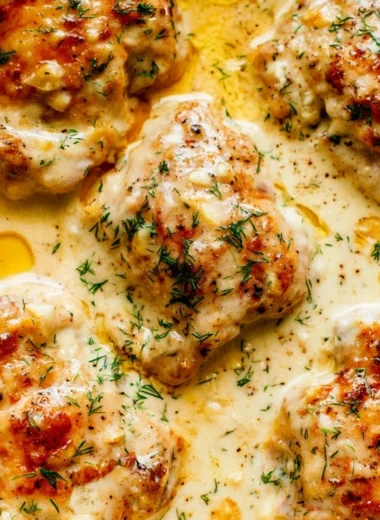 Creamy oven baked chicken thighs garnished with herbs