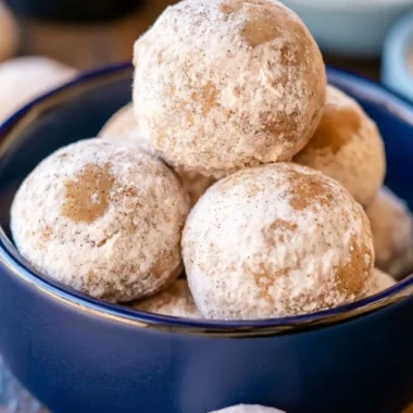 Plate of delicious Gingerbread Snowball Cookies dusted with powdered sugar